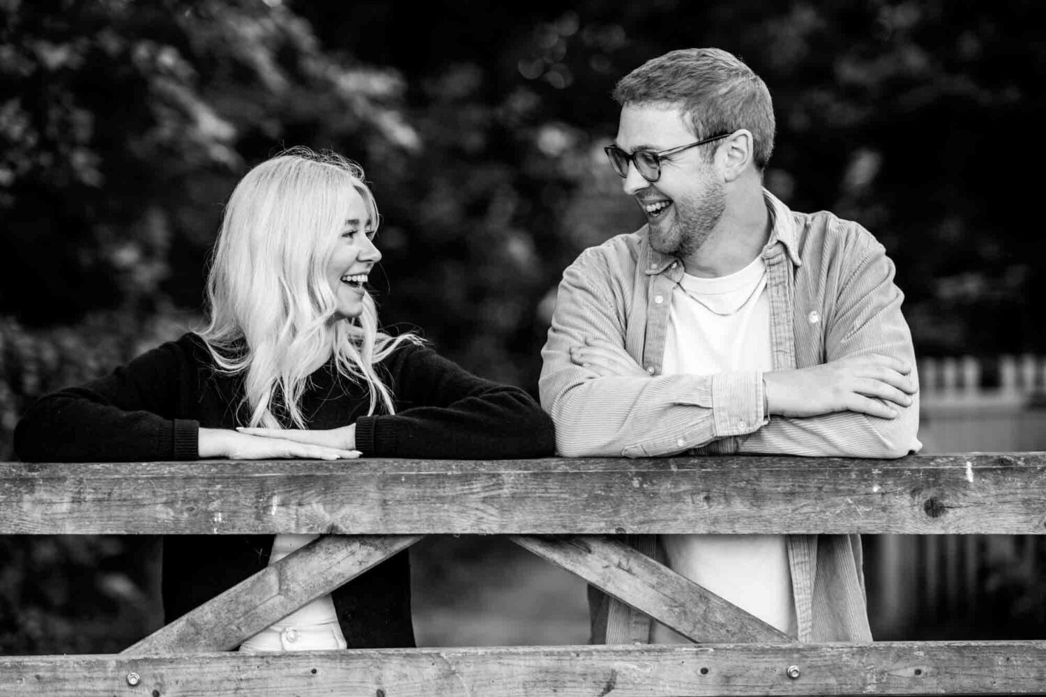 woman leaning on gate smiling at man